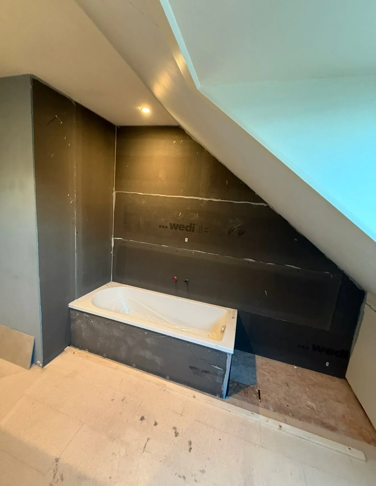 Badkamer in uitvoering met ingebouwd ligbad en waterdichting