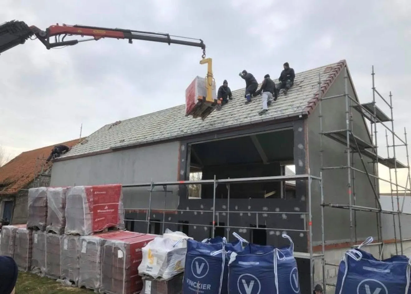 Plaatsing van de dakconstructie met kraan tijdens dakwerken