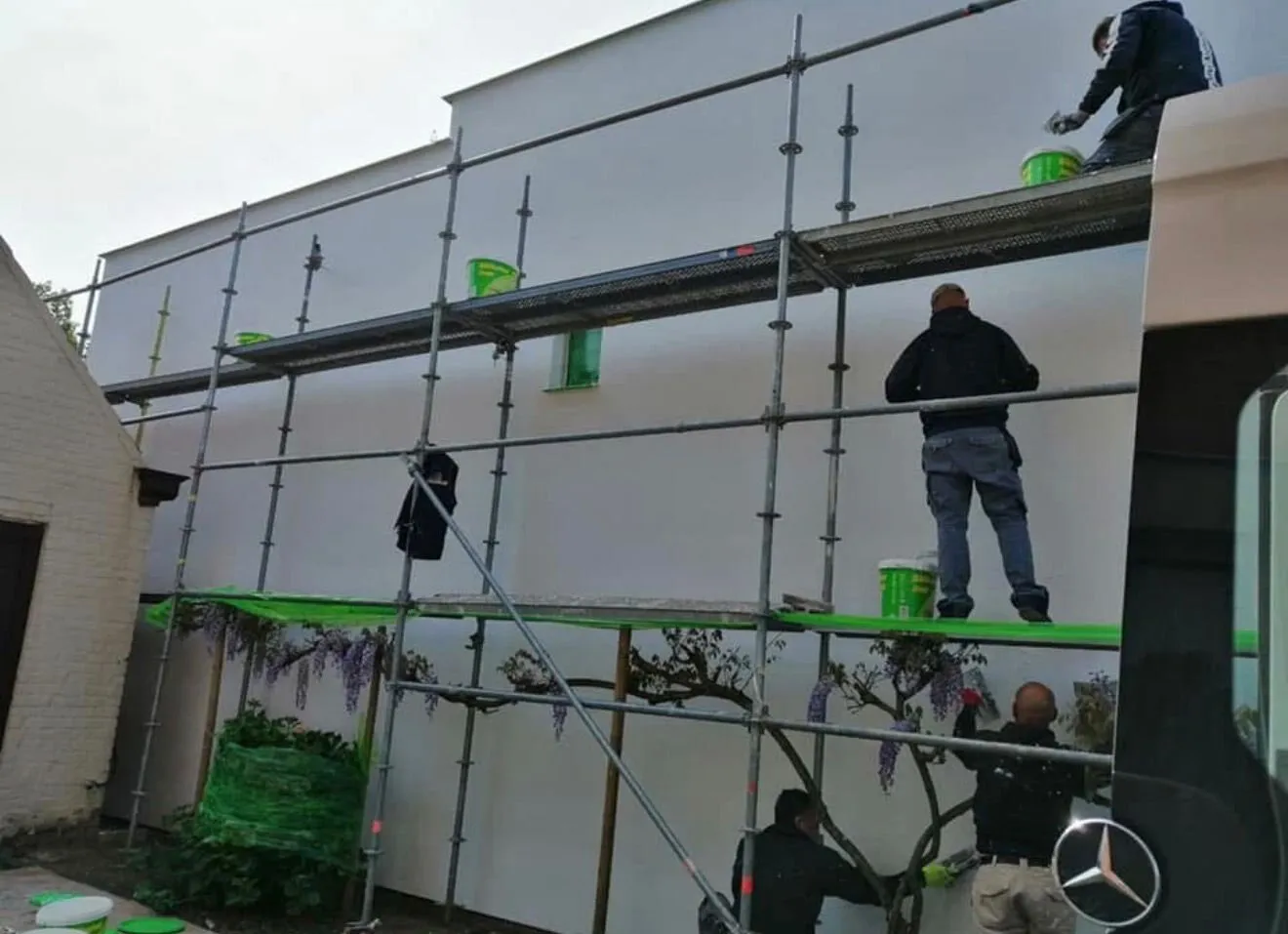 Ploeg van BHS Projects brengt de crepi-afwerking aan op de geïsoleerde gevel