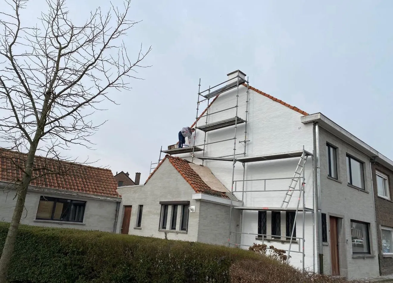 Woning in gevelisolatiewerken met steiger tegen de zijgevel