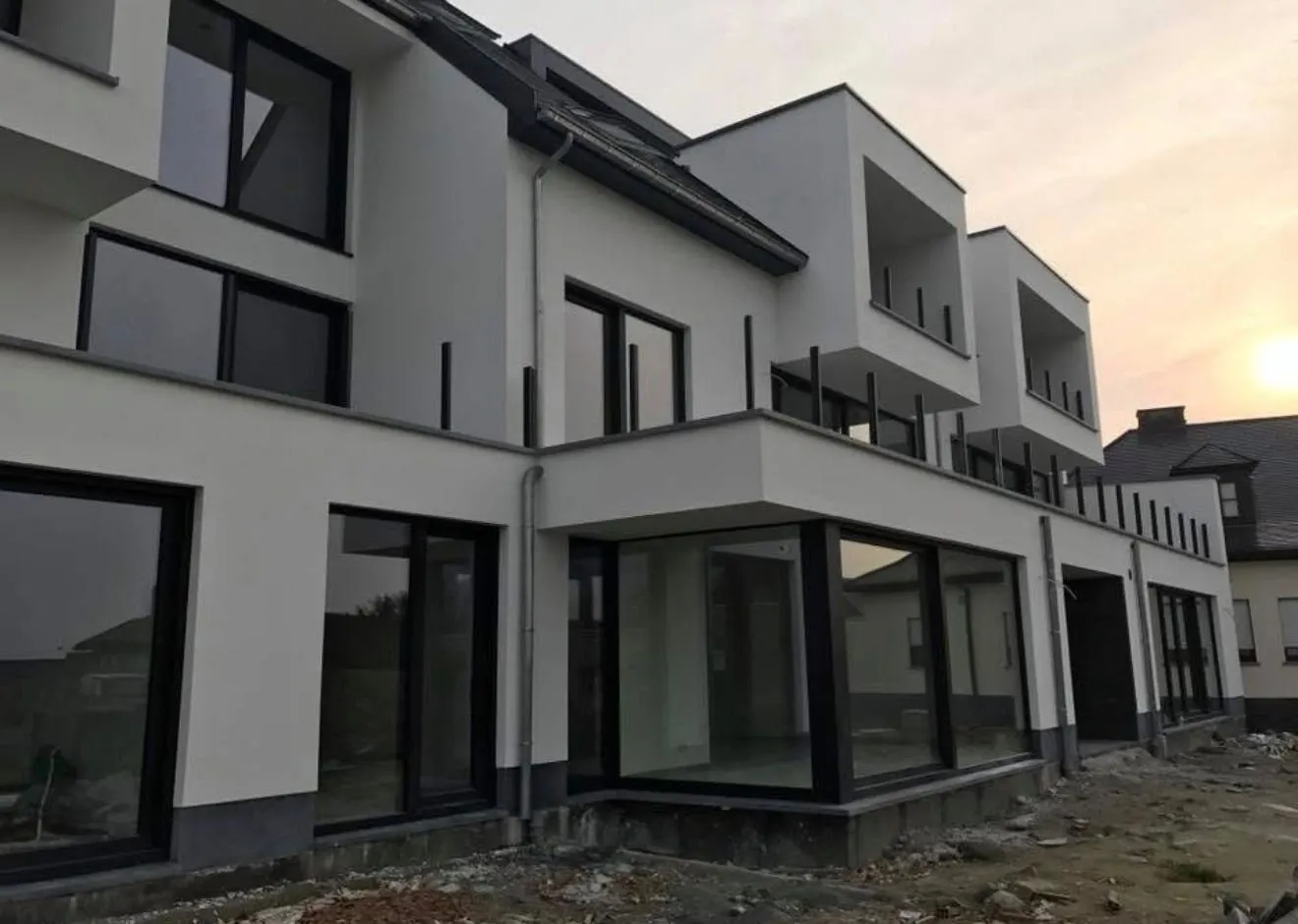 Nieuwbouwappartementen met afgewerkte witte gevel en zwart schrijnwerk