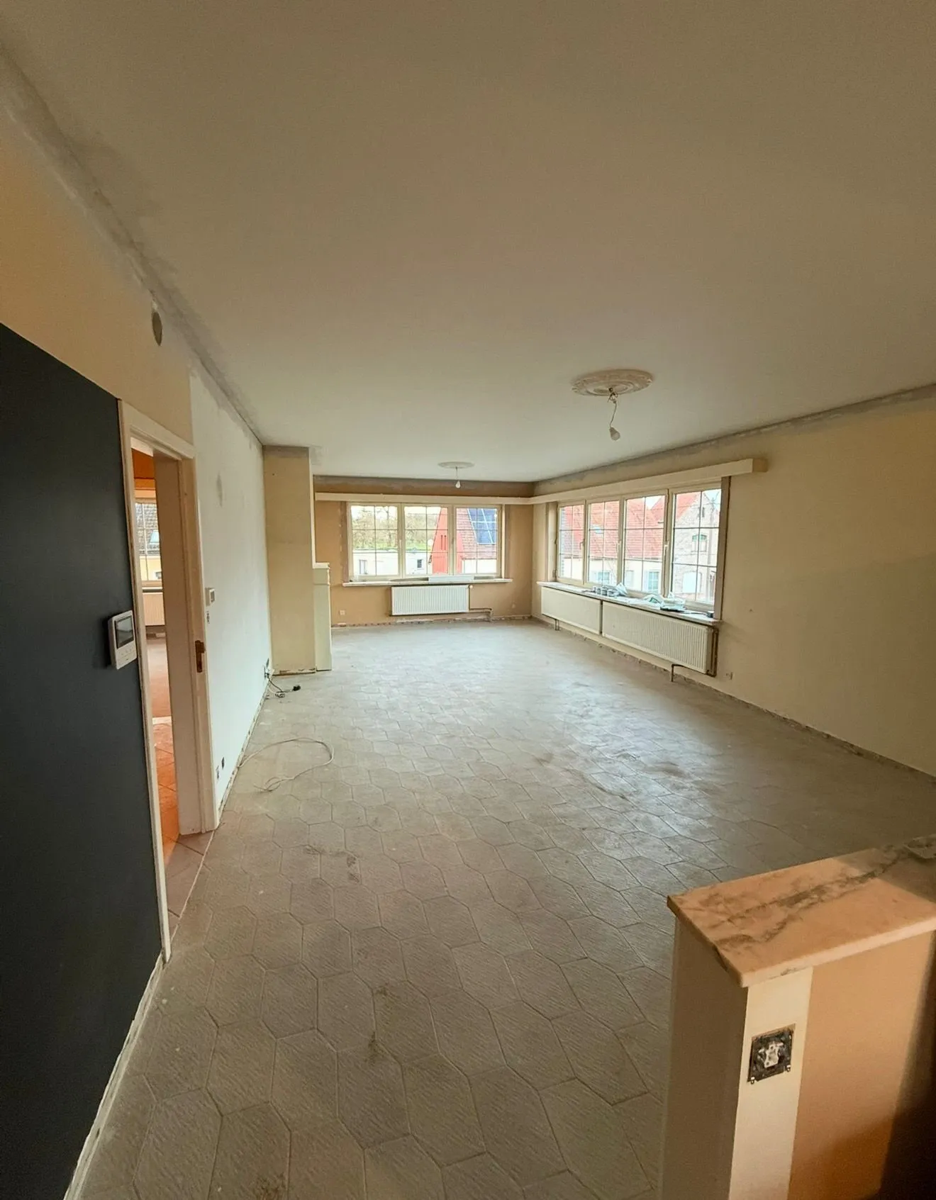 Lege leefruimte met oude vloer vóór de binnenrenovatie