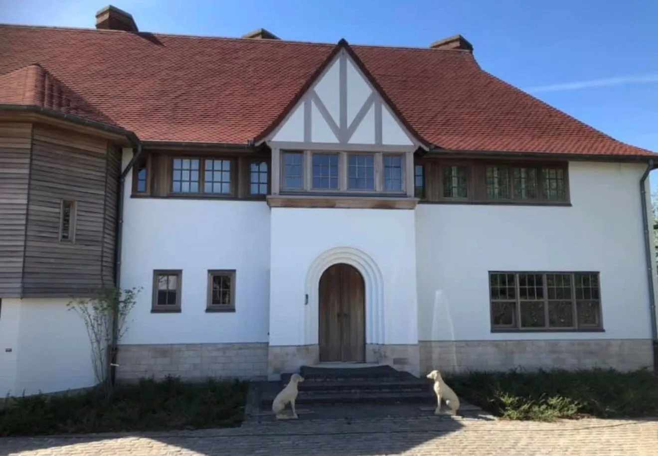 Dezelfde villa na de totaalrenovatie met witte gevel en nieuw schrijnwerk
